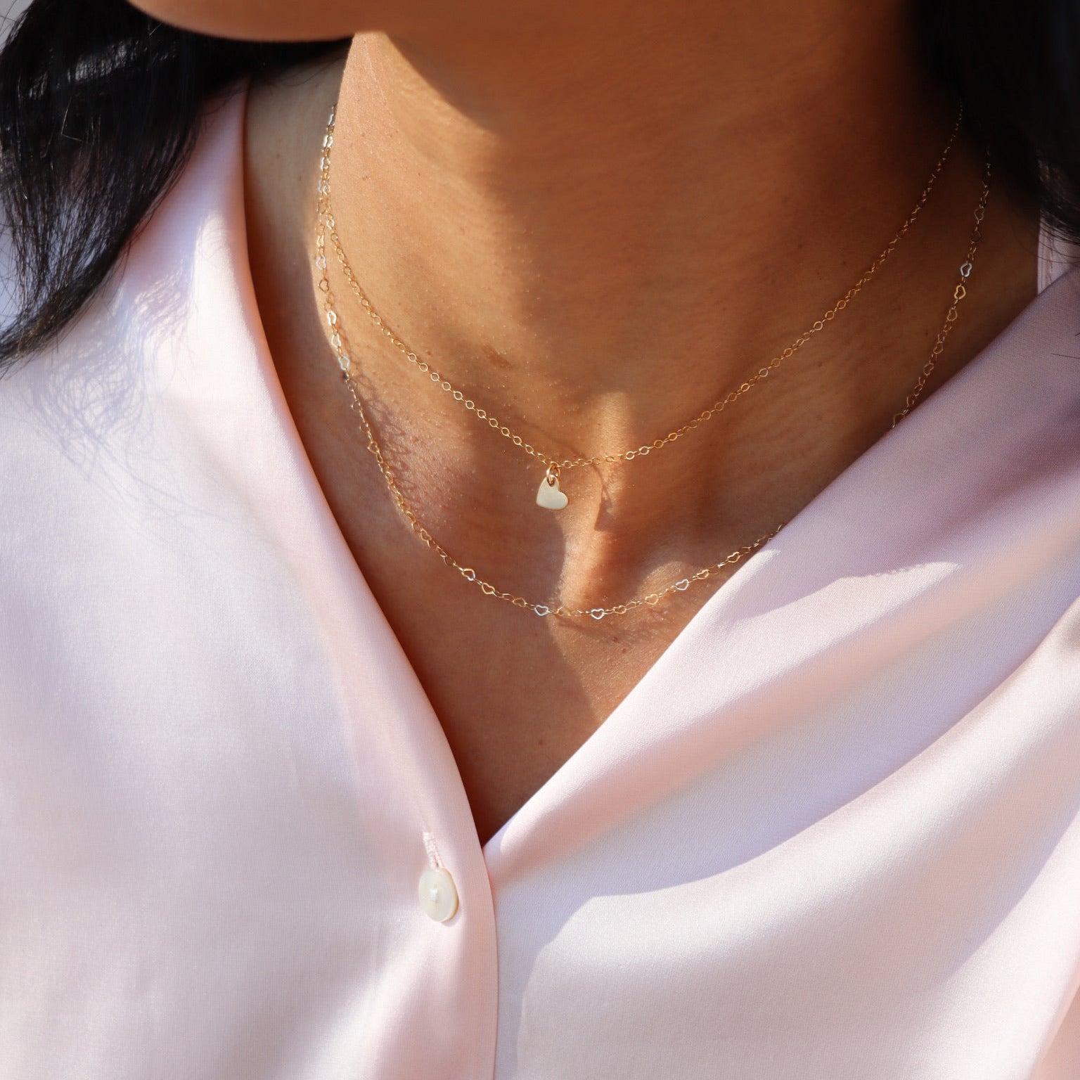 model wearing 14k gold fill dainty heart chain necklace paired with 14k gold fill dainty chain necklace with heart pendant