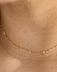 Model wearing the petite heart chain. This chain features a gold tiny heart wire throughout the whole chain. 