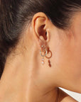 Pink pearl earrings on a brunette model