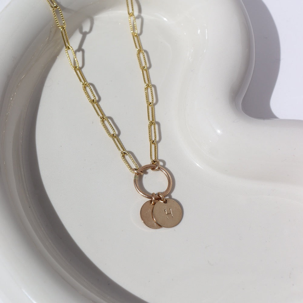 A textured chain-link style 14k gold fill necklace chain featuring a gold hoop, from which hangs two stamped discs