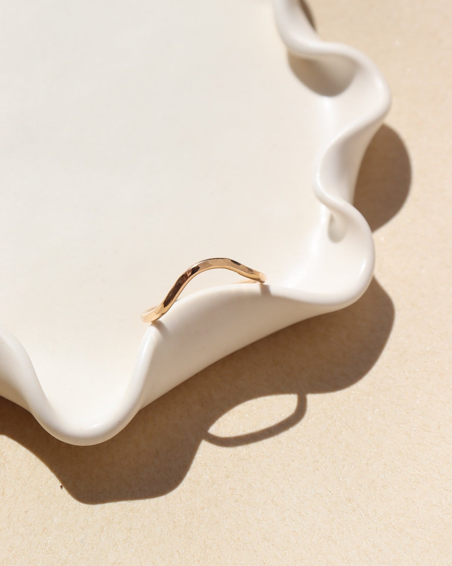 14k gold fill hammered ring with plunge detail on a light dish