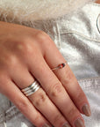 Model wearing a sterling silver red garnet ring. This ring features a 4mm red garnet stone on a thin sterling silver band. 