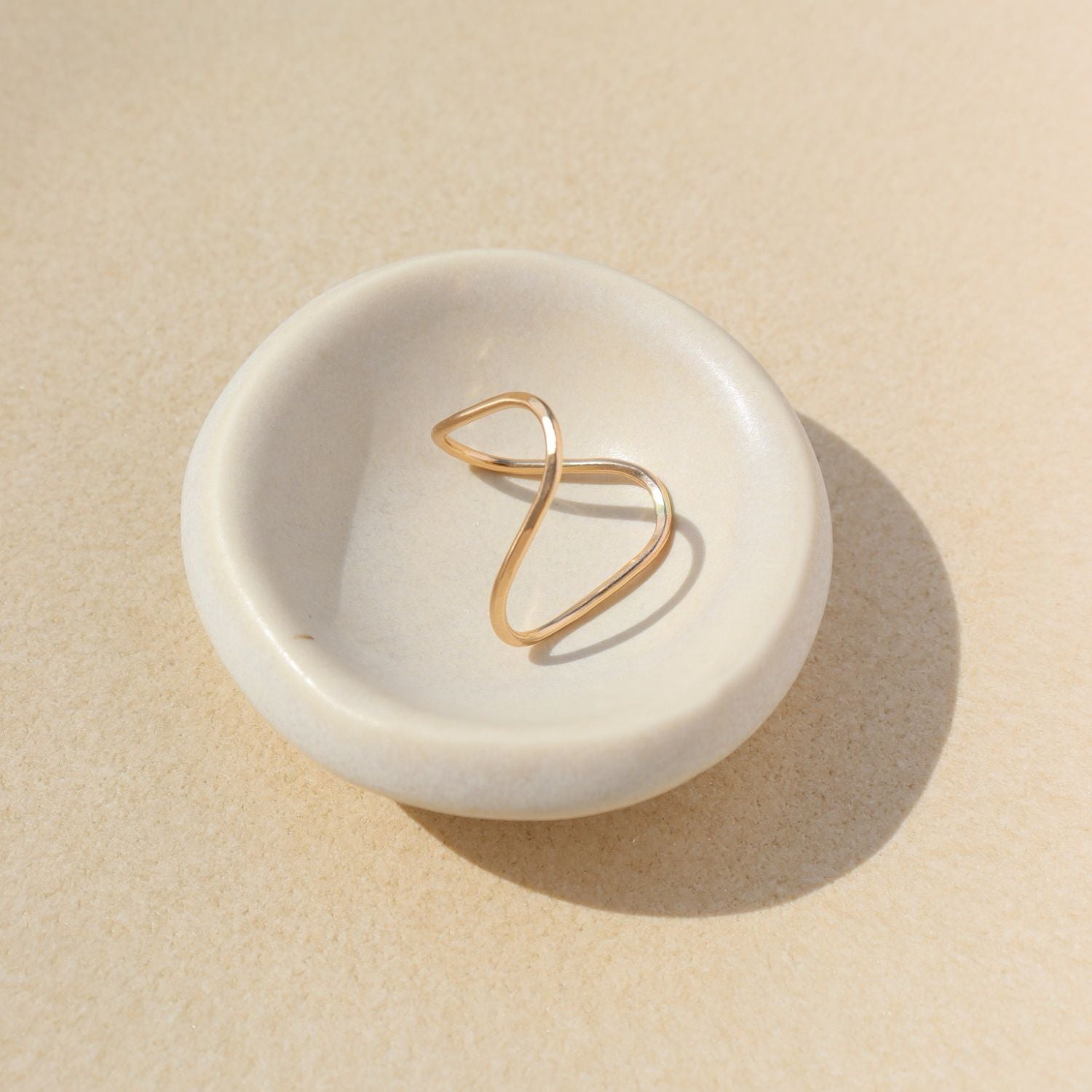 14k gold fill sculptural ring on a light bowl