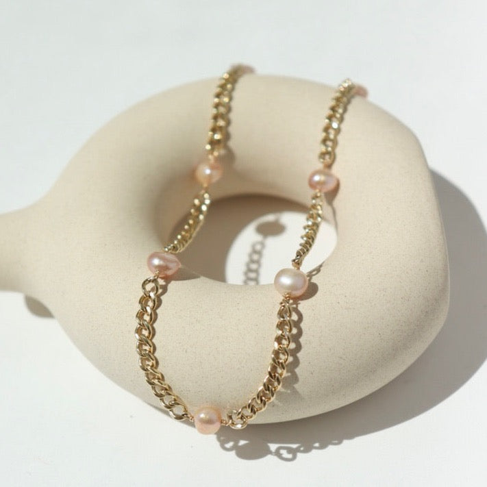 14k gold fill Rosalie Bracelet laid on a tan pot in the sunlight.