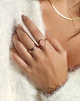 Model is wearing our rose quartz entwined ring in 14k gold fill, this ring features a rose quartz stone on a textured thick band. This band has a "entwined" textured look. The model is also wearing our Lainey ring, this is a thick gold band with ripples on the edges and a hammered band. 