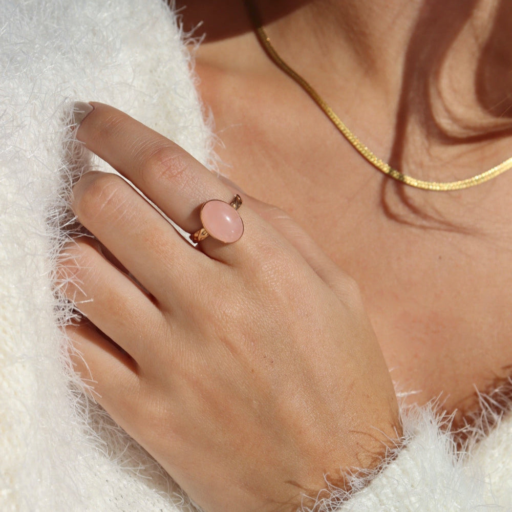 Model is wearing our rose quartz entwined ring in 14k gold fill, this ring features a rose quartz stone on a textured thick band. This band has a "entwined" textured look. 