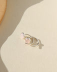 Our rose quartz Huggies feature a 5mm rose quartz gemstone. These earrings are made to hug your ear featuring a curved sterling silver post that will wrap around your ear. The earrings are on a white backdrop. 