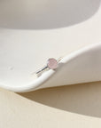 Sterling silver ring featuring a 5mm rose quartz gemstone set in a sterling silver thin band. The ring is displayed on a white dish. 