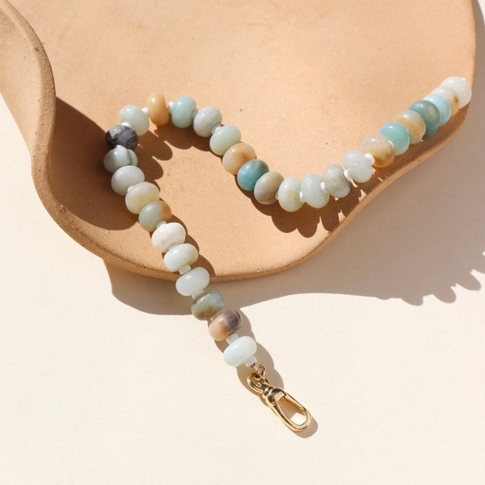 A fully beaded 14k gold fill anklet filled with amazonite gemstones and shell spacer beads. The anklet is displayed on a orange dish. 