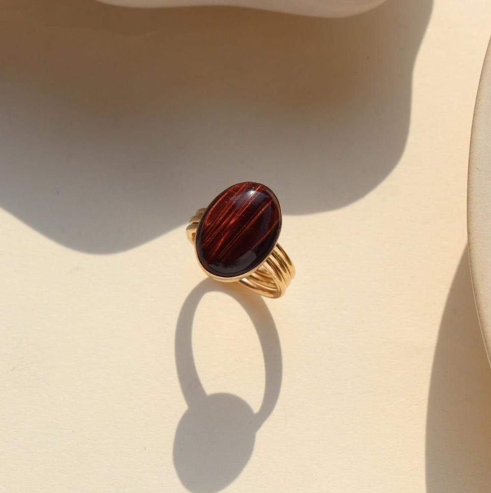 The Scarlett Ring, available in 14k gold fill or sterling silver, features a stunning Red Tiger Eye gemstone on a triple 14k gold fill band