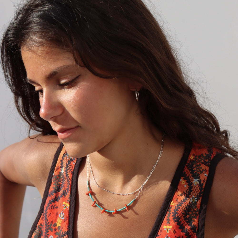 Model wearing Sedona Necklace with turquoise tube beads and red coral accents on a delicate gold filled chain.