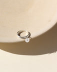 A smooth band stacked with a spiral sterling silver band, with a small "A" stamped disc attached to both rings. 