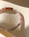 Beaded bracelet on a textured beige surface with soft shadows