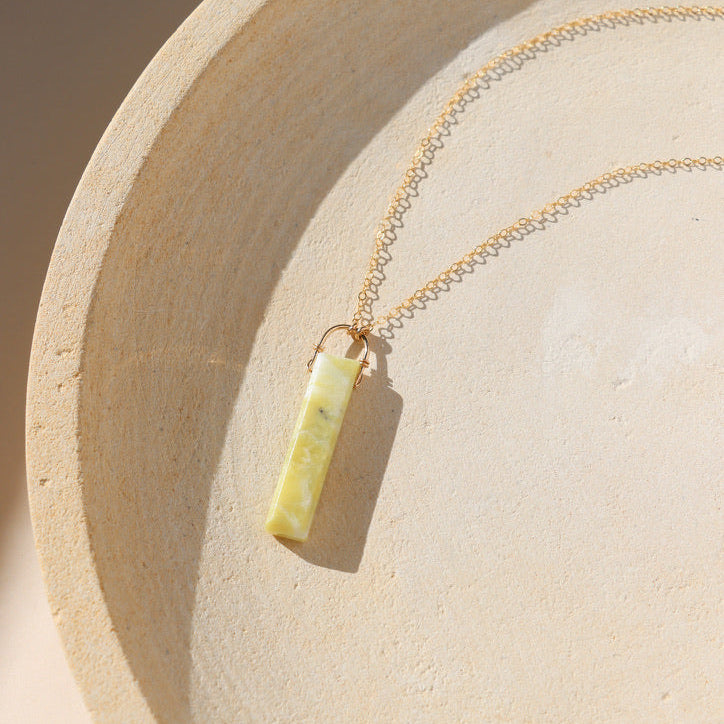 14k gold fill chain necklace with rectangle serpentine pendant on a light dish