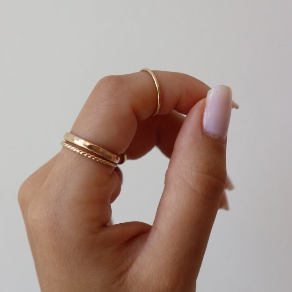 Model wearing 14k gold fill hammered rings and a spiral ring