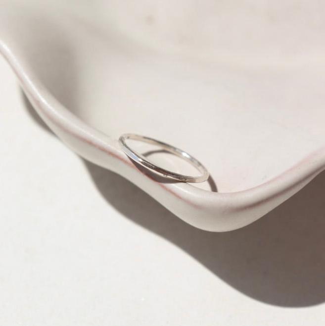 sterling silver hammered band ring on a light dish