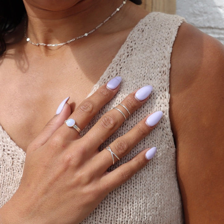 model wearing sterling silver ring with blue lace agate stone paired with sterling silver rings