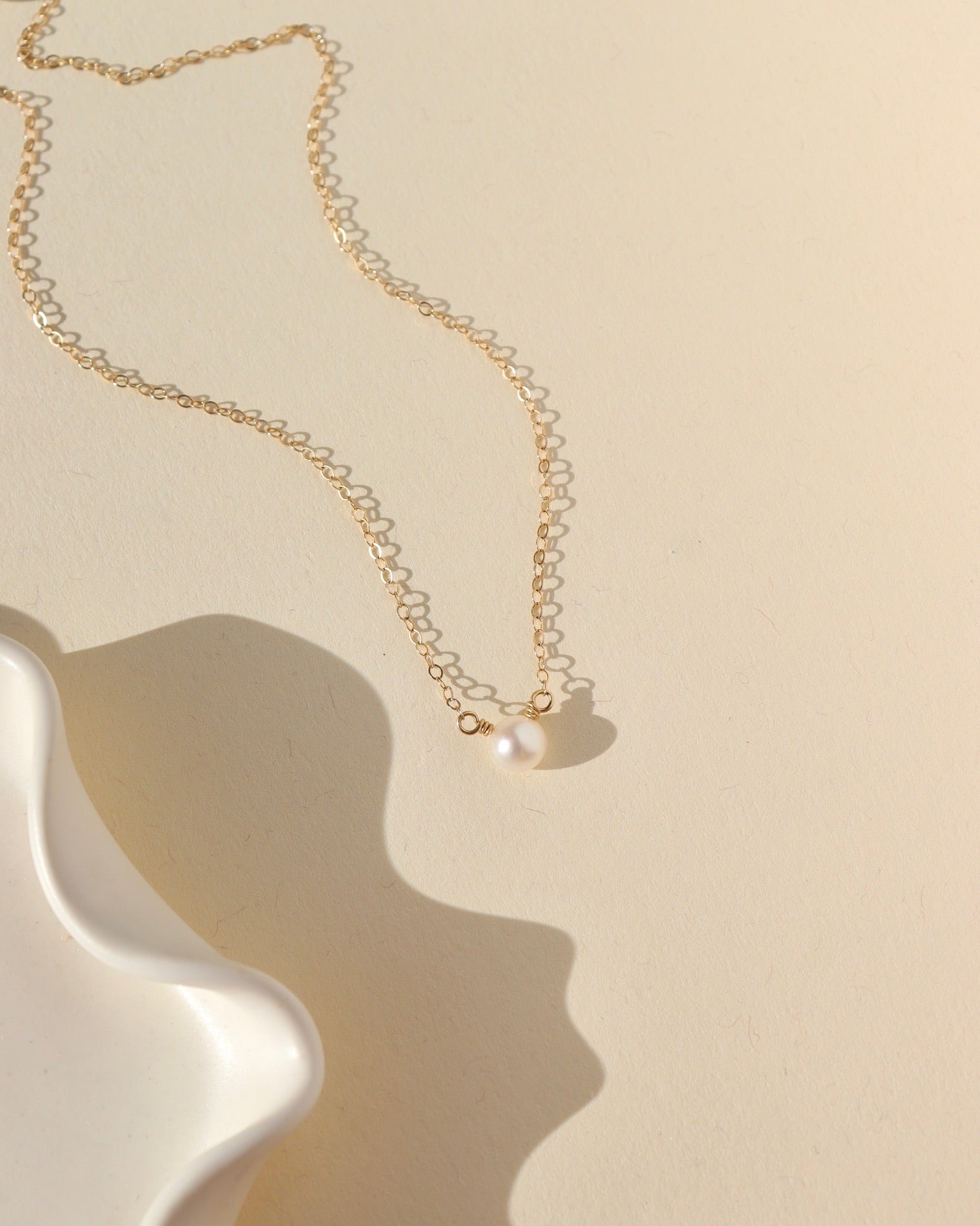 mother of pearl bead wrapped onto a dainty 14k solid gold necklace chain