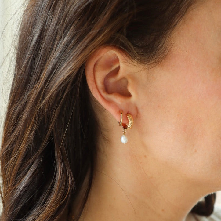 model wearing 14k gold fill floral hoop studs with edison pearls dangling paired with a 14k gold fill hoop earring