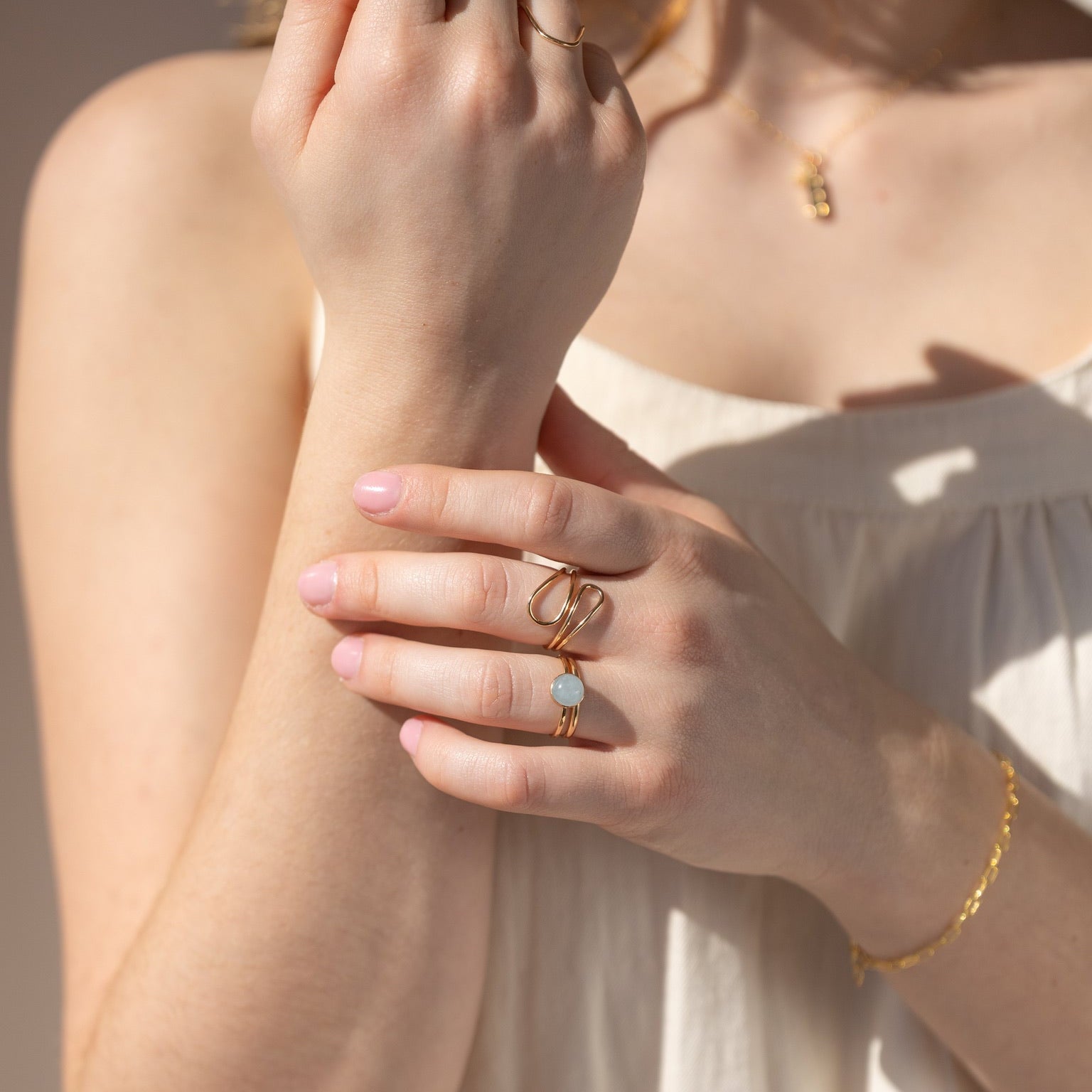 model wearing 14k gold fill wavy ring  paired with other 14k gold fill rings