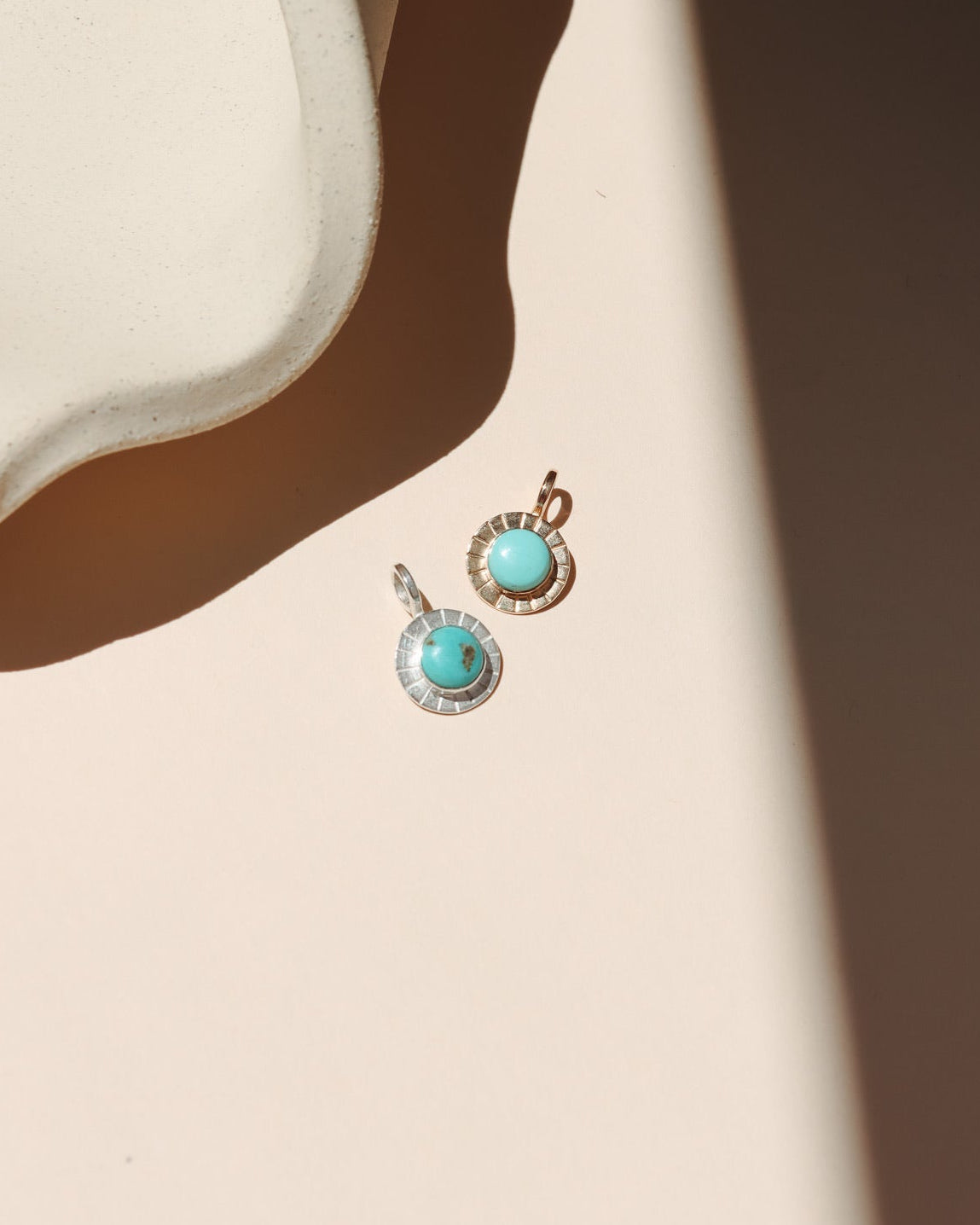 14k gold fill and sterling silver charms with round turquoise stones in the sunlight