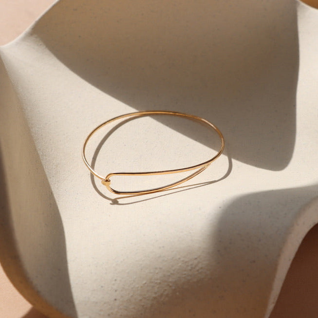 14k gold fill wire bracelet on a light dish
