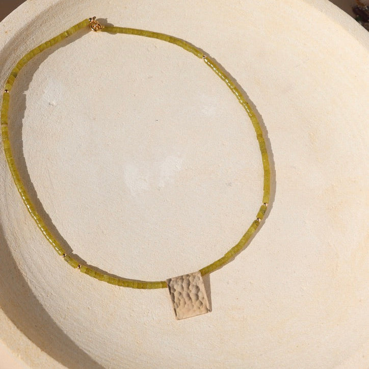 jade beaded necklace with 14k gold fill pendant on a light background