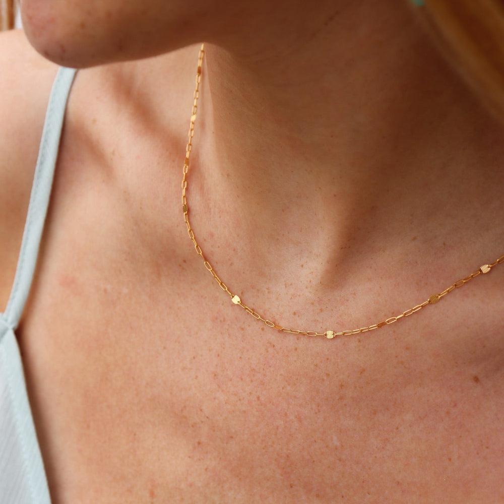 Model wearing 14k gold filled Sunspell Chain featuring delicate, light-reflecting links designed for layering or everyday wear.