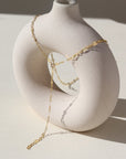 14k gold fill lariat chain, photographed on a cream colored ceramic dish