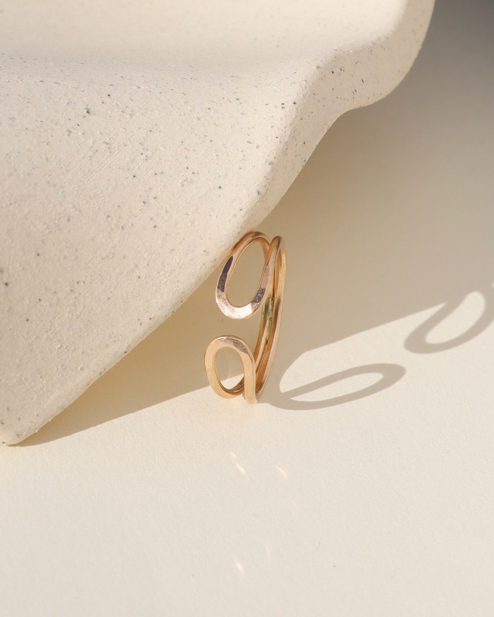 14k gold fill hammered sculptural ring by a light dish
