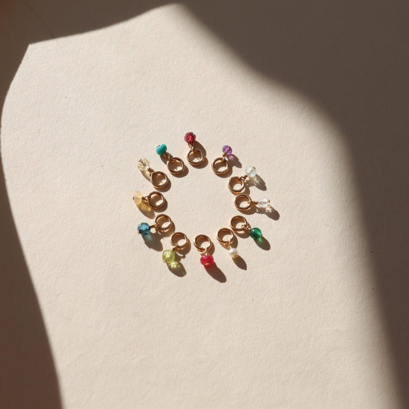 circle of tiny birthstone gemstones on jump rings in the sunlight