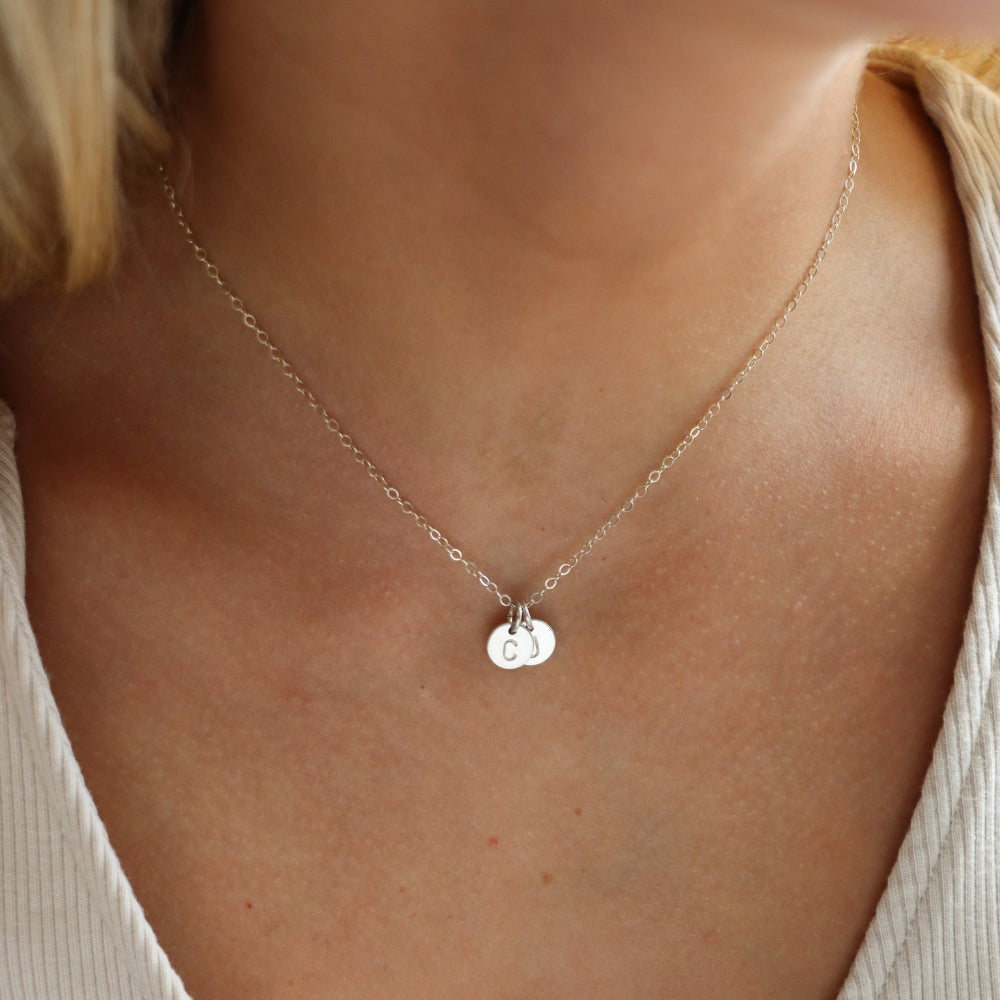 model wearing sterling silver delicate chain necklace with 2 stamped disc charms