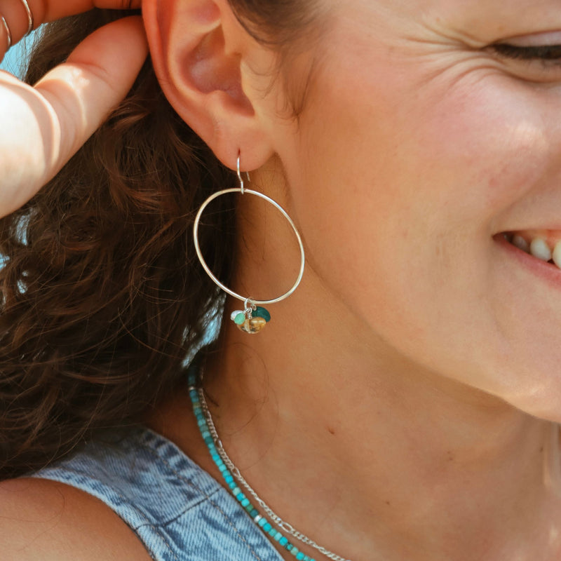 model wearing sterling silver hoops with gemstones and beaded turquoise necklace