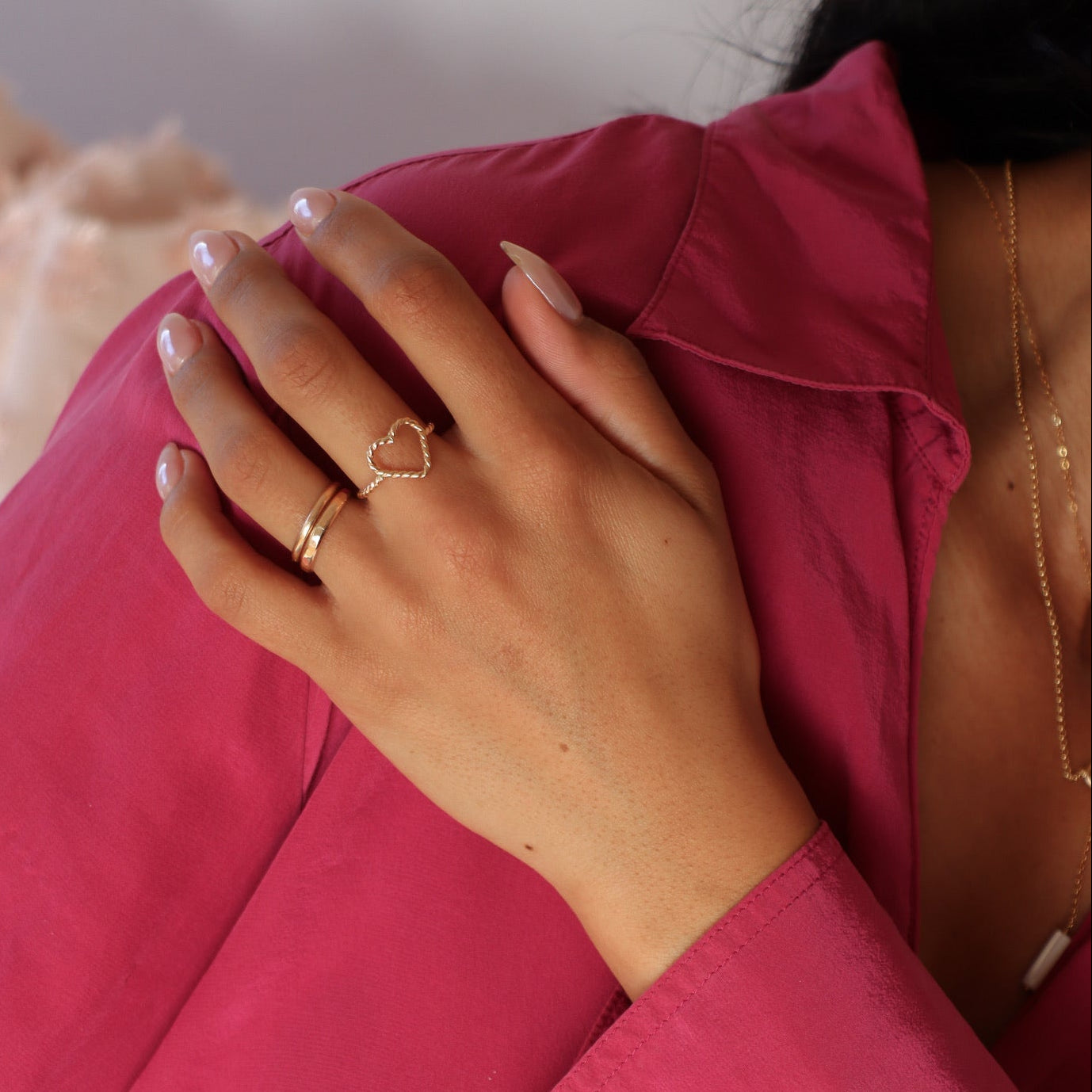 model wearing 14k gold fill heart spiral ring paired with two 14k gold fill stacking rings