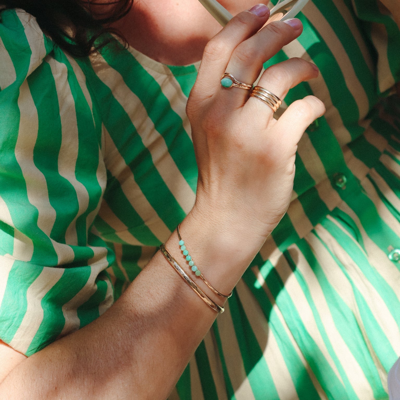 model wearing sterling silver jewelry including a cuff with wire wrapped chrysoprase stones 