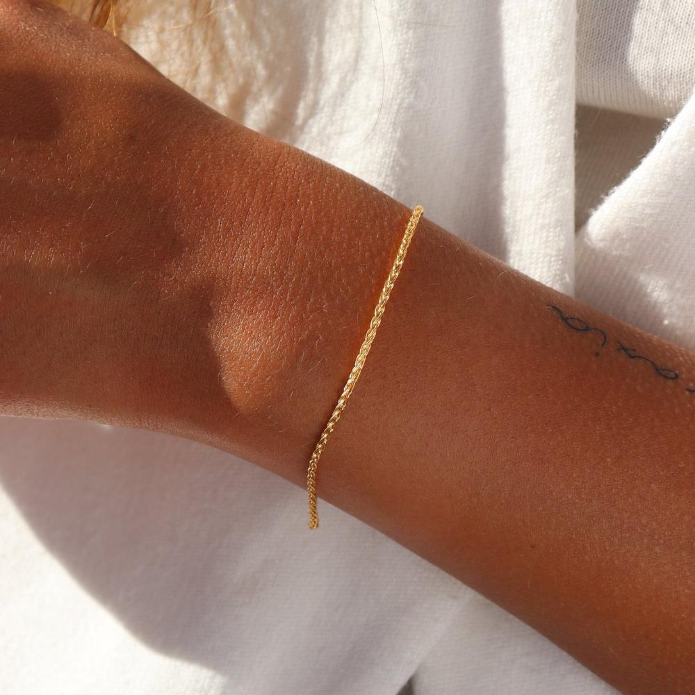 Westly bracelet by Token Jewelry photographed on a model. The bracelet is a delicate 14k gold wheat-inspired chain.