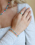 Model wearing a vibrant colorful bracelet filled with a mix of different opal gemstones. This bracelet has a 14k gold fill standard clasp a 0.5" extender. 