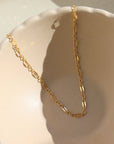 14k gold fill Sylvie choker laid on a tan plate in the sunlight. 