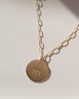 14k gold fill angel number pendant on a gold fill chain, photographed on a ceramic dish