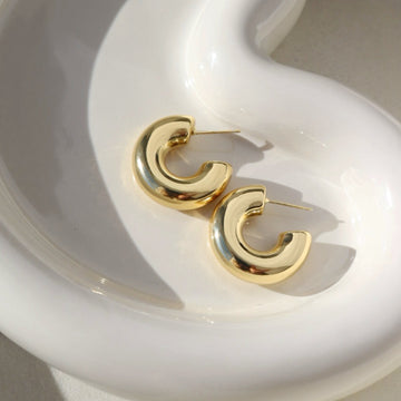 14k gold fill chunky hoop studs, laid on a white plate.