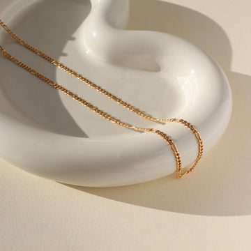 14k gold fill Capri Chain laid on a white plate. Handmade in Eau Claire Wisconsin.