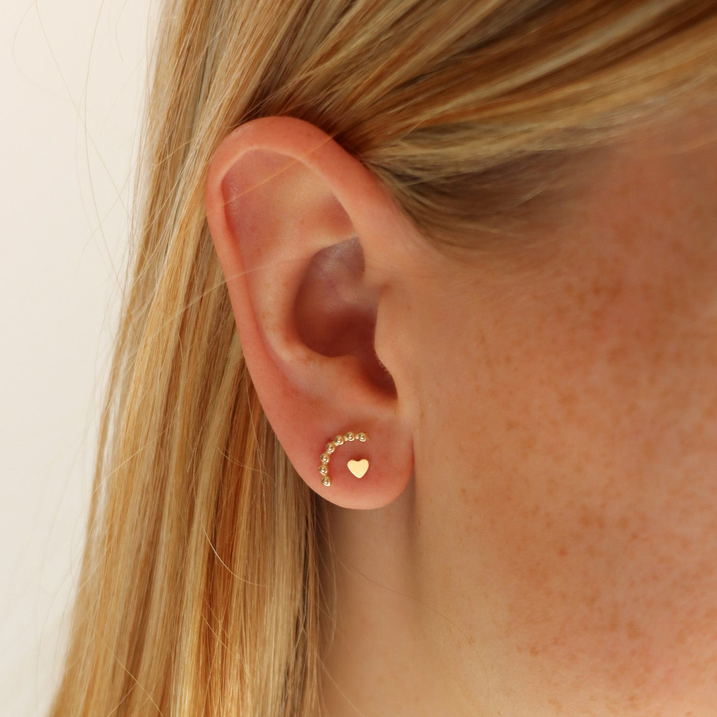 model wearing 14k gold fill sequin wire stud earrings on a light background