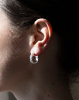 925 sterling silver 3/4" hoop earrings featuring a wave texture photographed on a brunette model