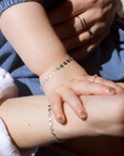 mother and daughter's hands wearing matching 925 sterling silver starlight bracelets